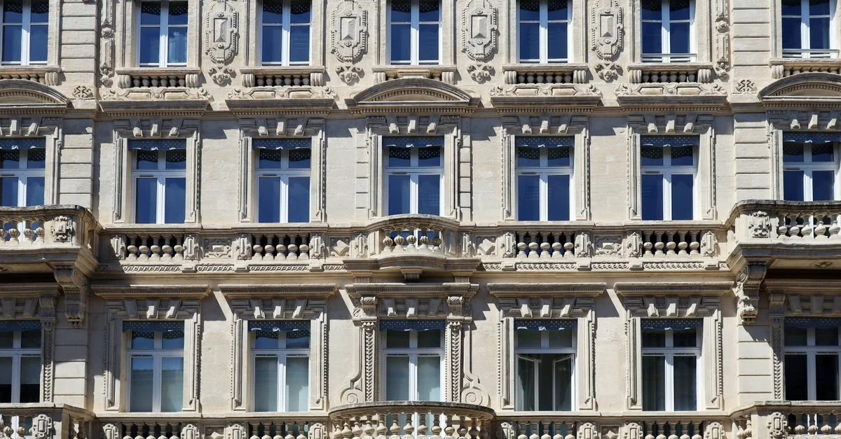 Vue détaillée d'une façade de bâtiment historique à Avignon, mettant en valeur l'architecture française classique.