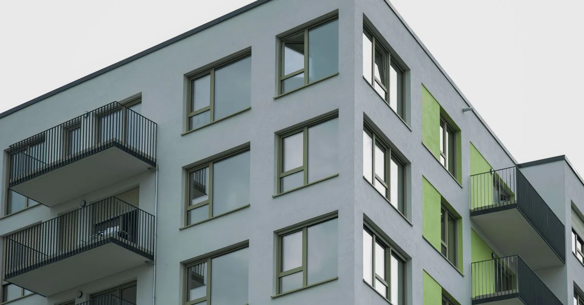Architecture contemporaine d'un complexe d'appartements moderne avec balcons visibles et accents colorés.