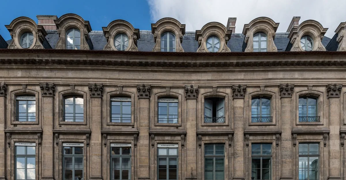 Vue détaillée d'une façade parisienne historique du 19e siècle par temps clair.