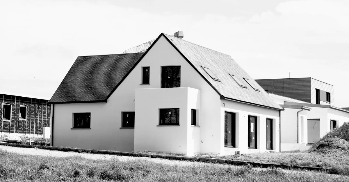 Image en noir et blanc d'une maison unifamiliale moderne en construction.